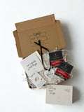 Gift box with tea bags, heart keepsake, small keyring a card, and a note on a white background