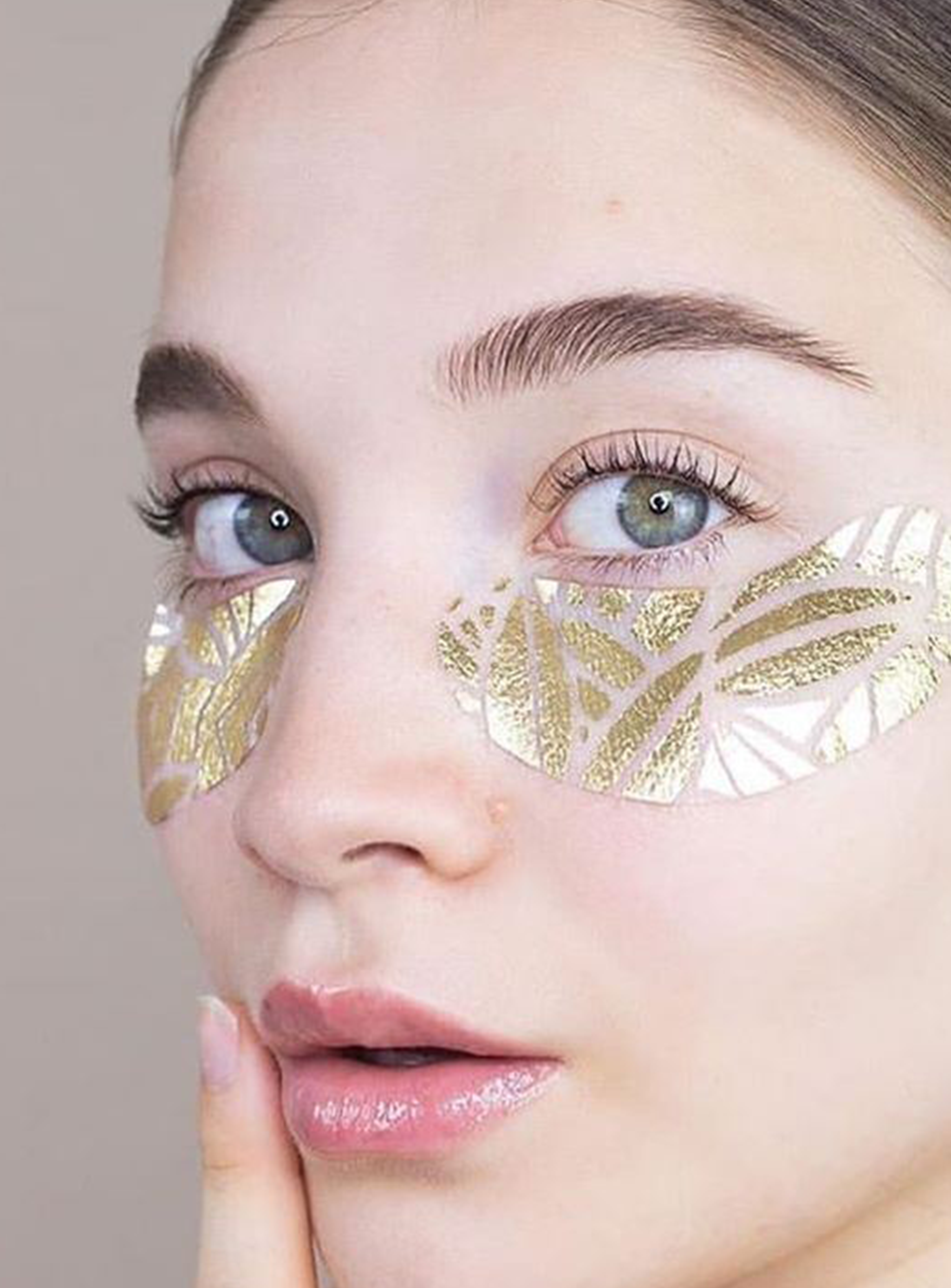 Close-up of a person wearing gold eye mask.