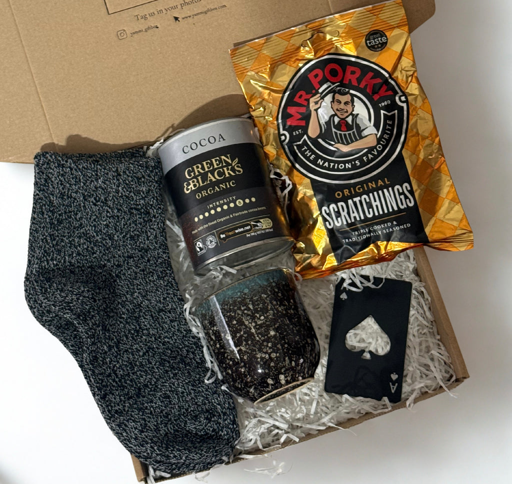 Box with socks, a can of coffee, and a packet of 'Mr. Porky's' scratchings on a white background