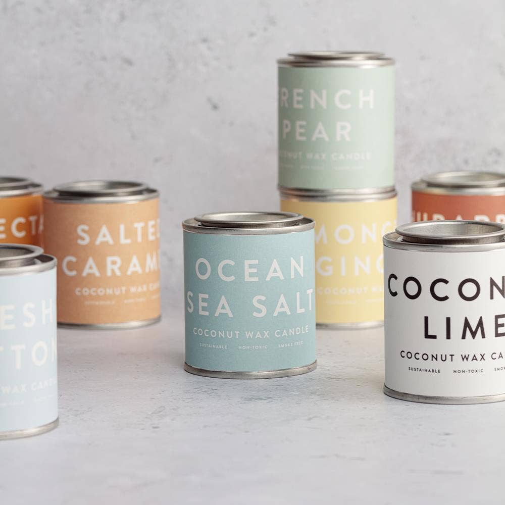 Assorted cans of coconut wax candles with labels.