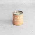 Candle in a can labeled 'Salted Caramel'.