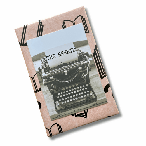 Product packaging with a vintage typewriter design and 'THE NEWEIE' text.