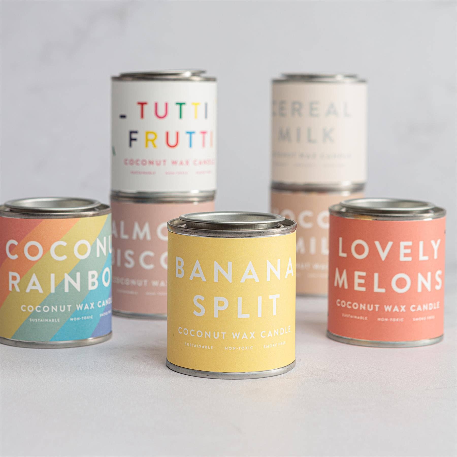 Set of coconut wax candles in various flavors with colorful labels.