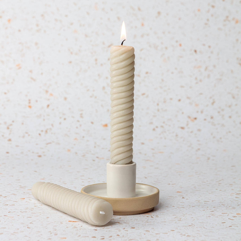 Ceramic candle holder with a twisted candle.