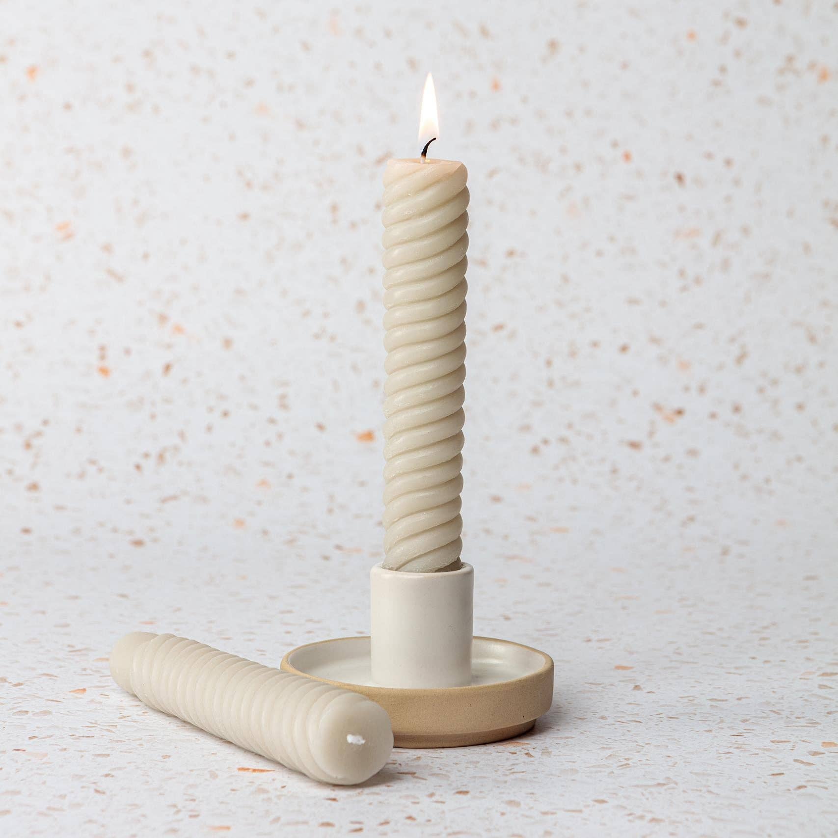 Ceramic candle holder with a twisted candle.