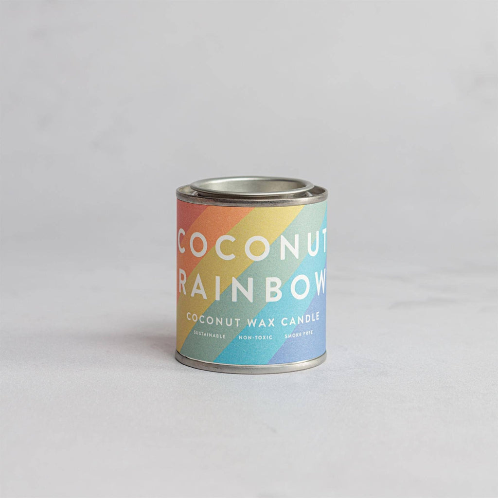 Coconut Rainbow candle in a tin with a colorful label.