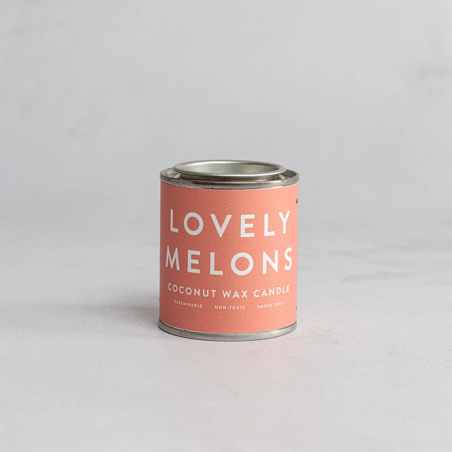 Candle in a can labeled 'Lovely Melons'.