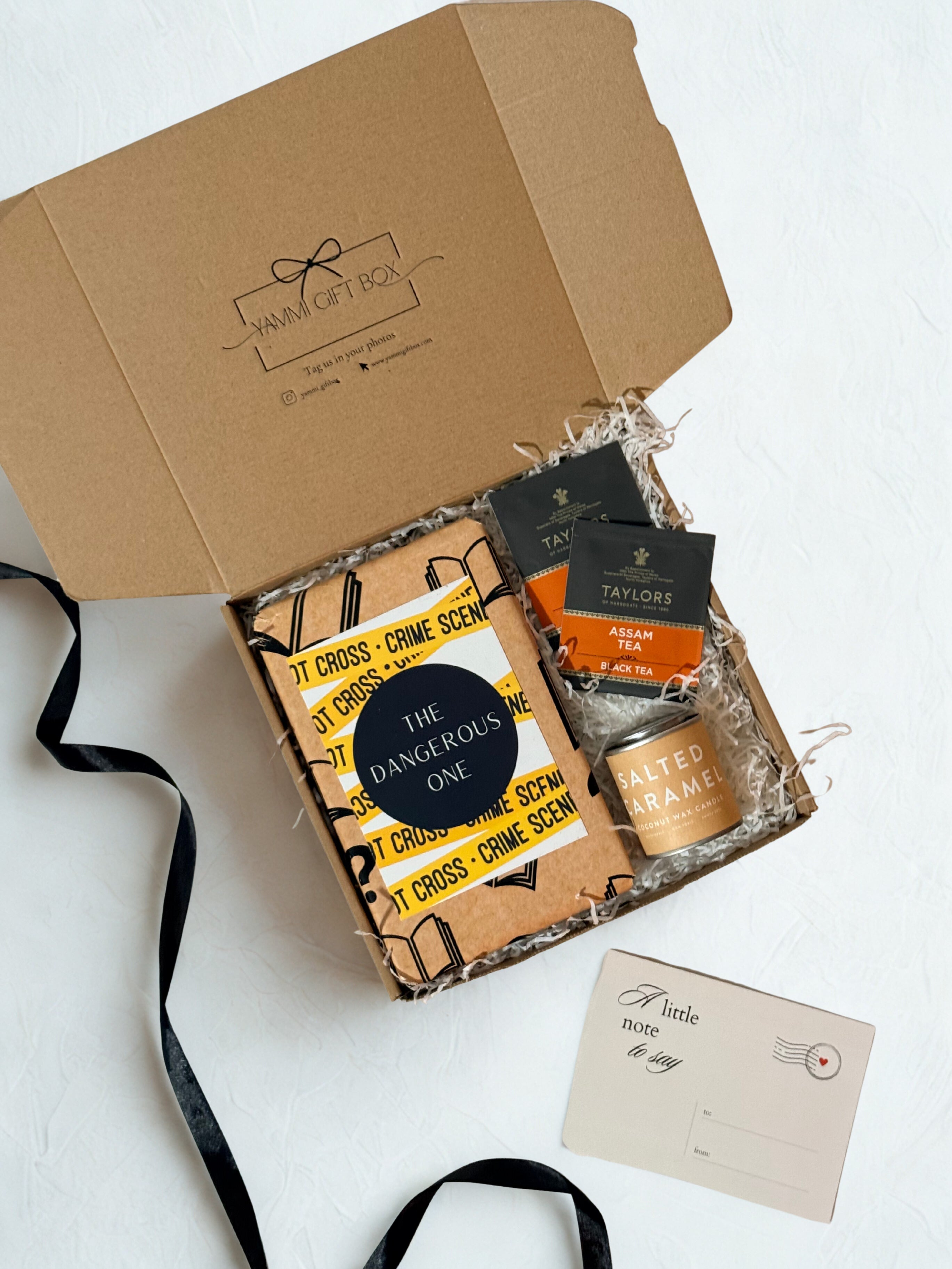 Gift box with books, tea, candle and a card on a white background
