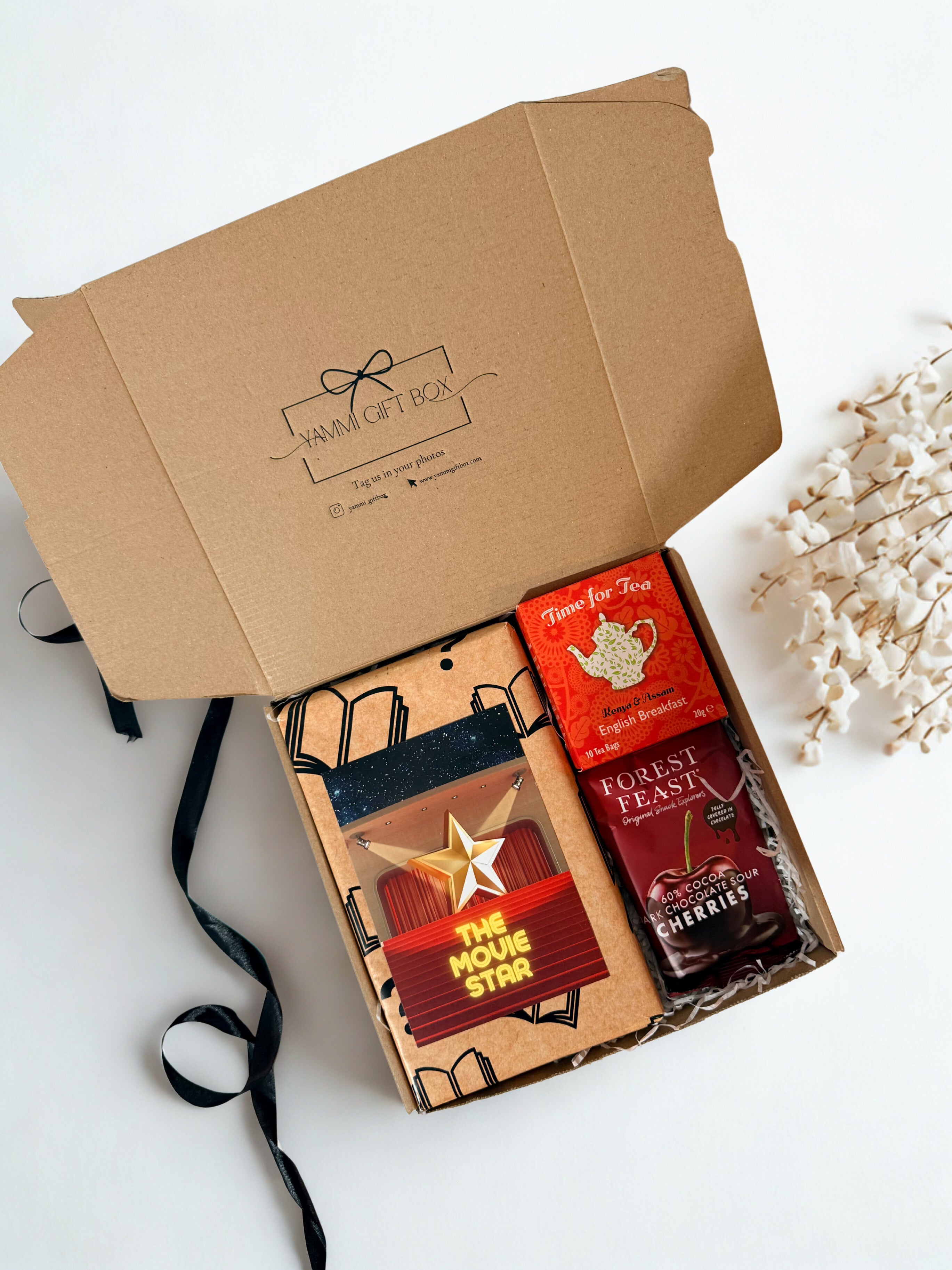 gift box with blind date with a book book, dark chocolate sour cherries and tea.