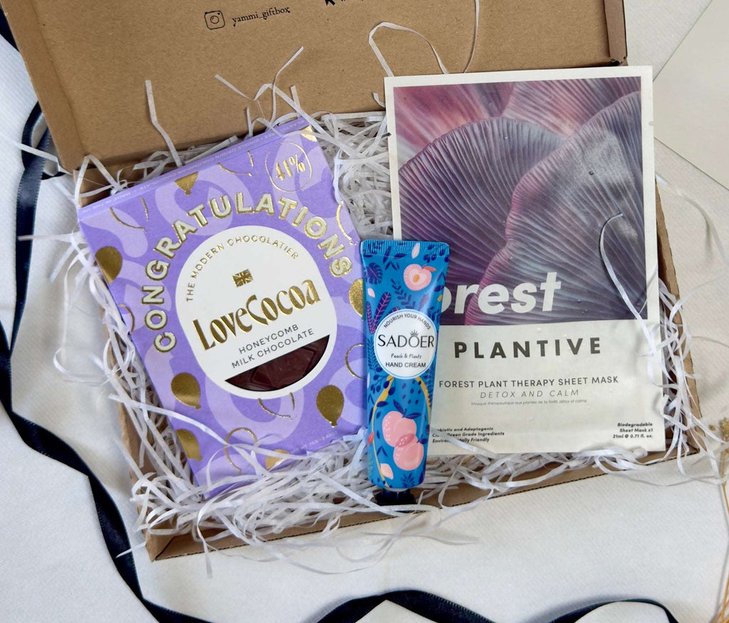 Box with chocolate bar, skincare product, and plant-based sheet mask.