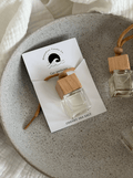 Car perfume bottle with wooden cap on a branded card.