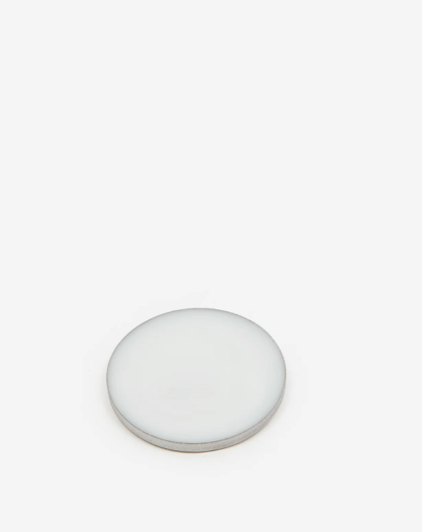 Round white object on a light beige background