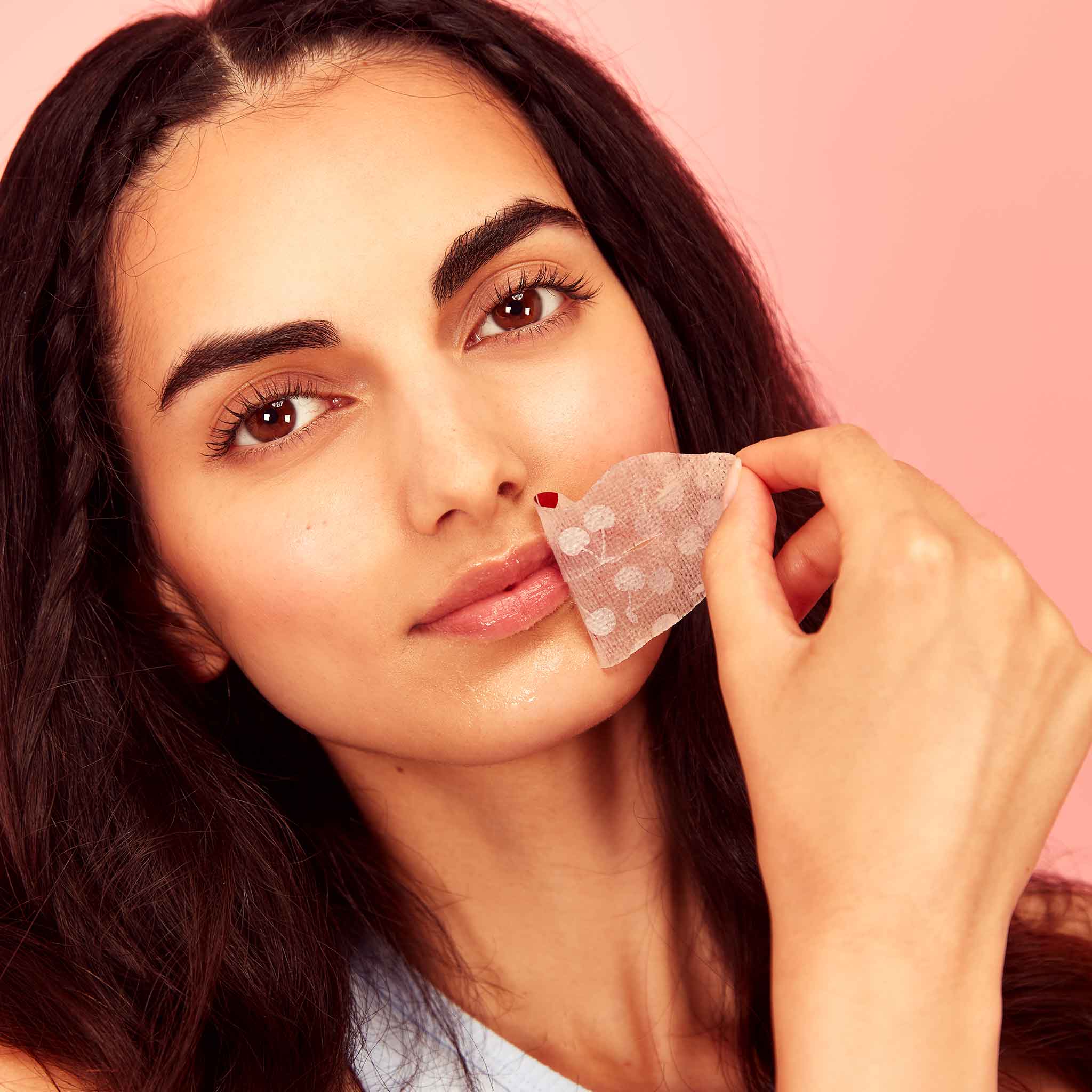 Woman applying cherry vegan collagen lip mask with heart-shaped details, showcasing hydrating lip care.