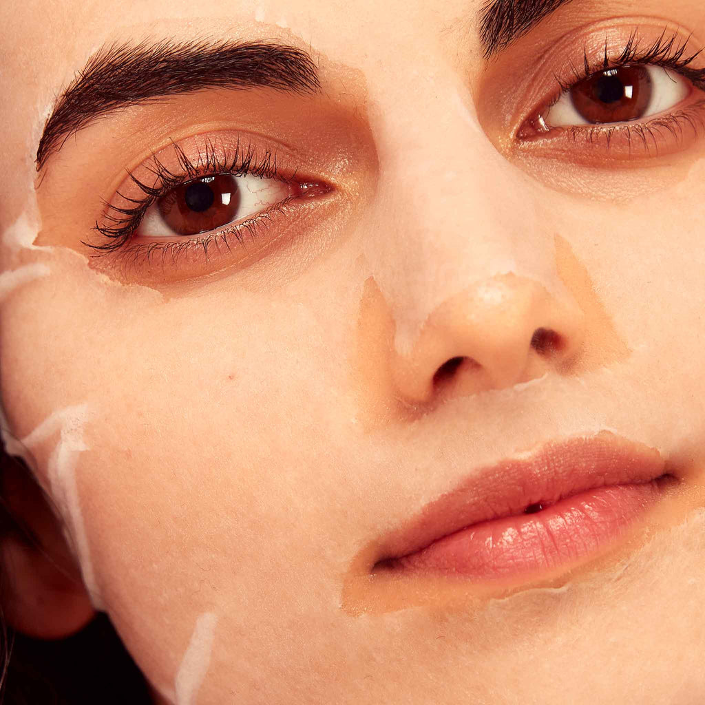 Close-up of a person's face with a white cream applied to the skin.