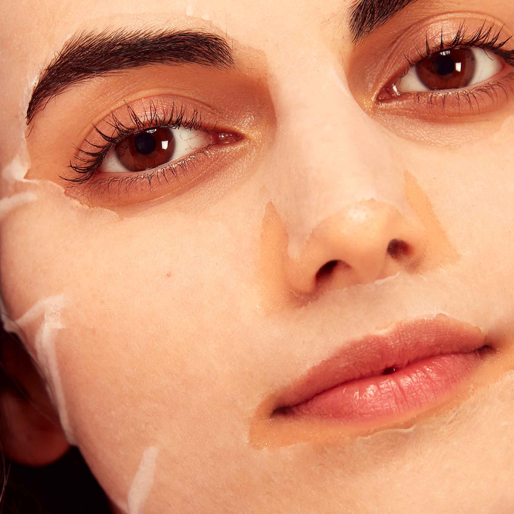 Close-up of a person's face with a white cream applied to the skin.