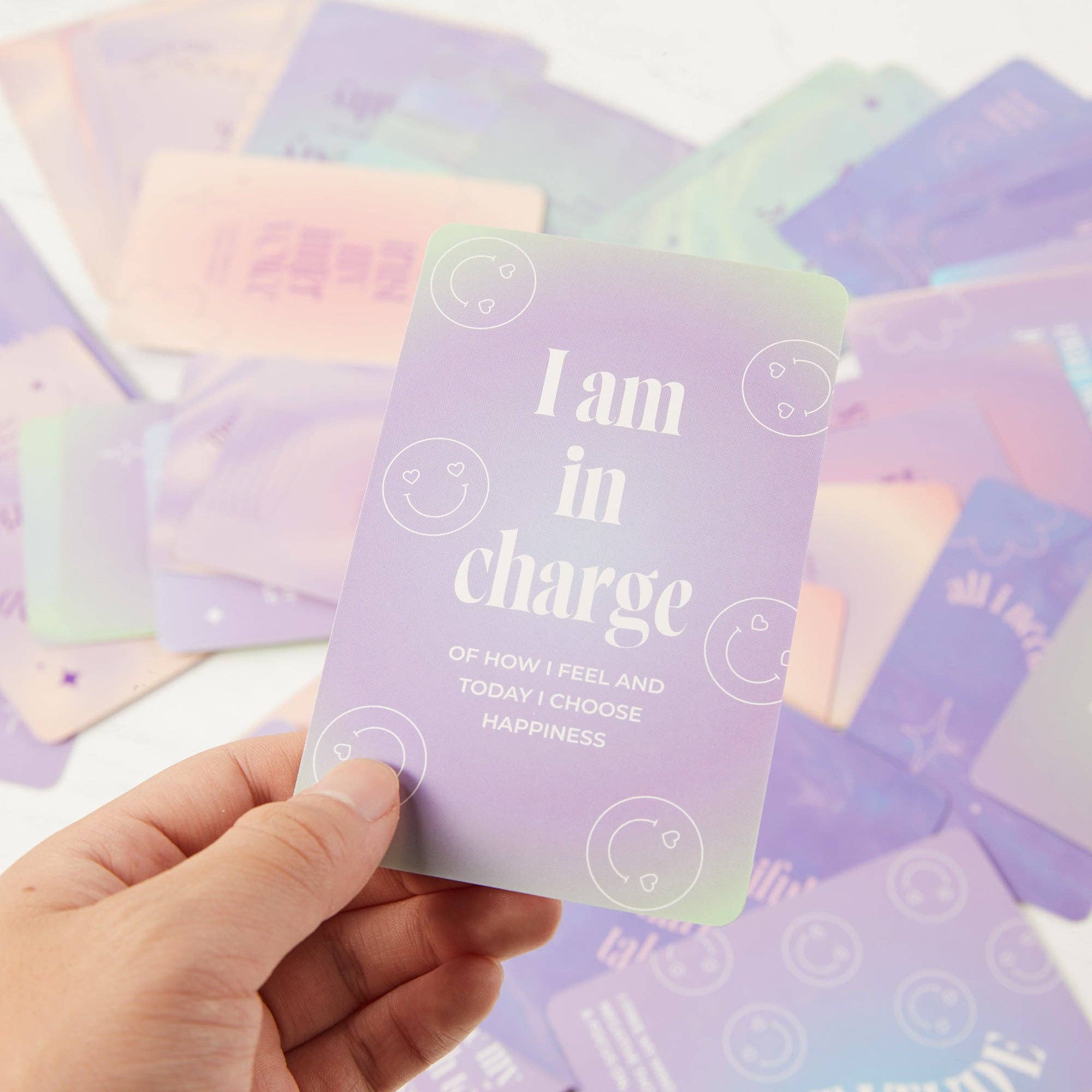 Hand holding a motivational card with 'I am in charge' text against a background of similar cards.