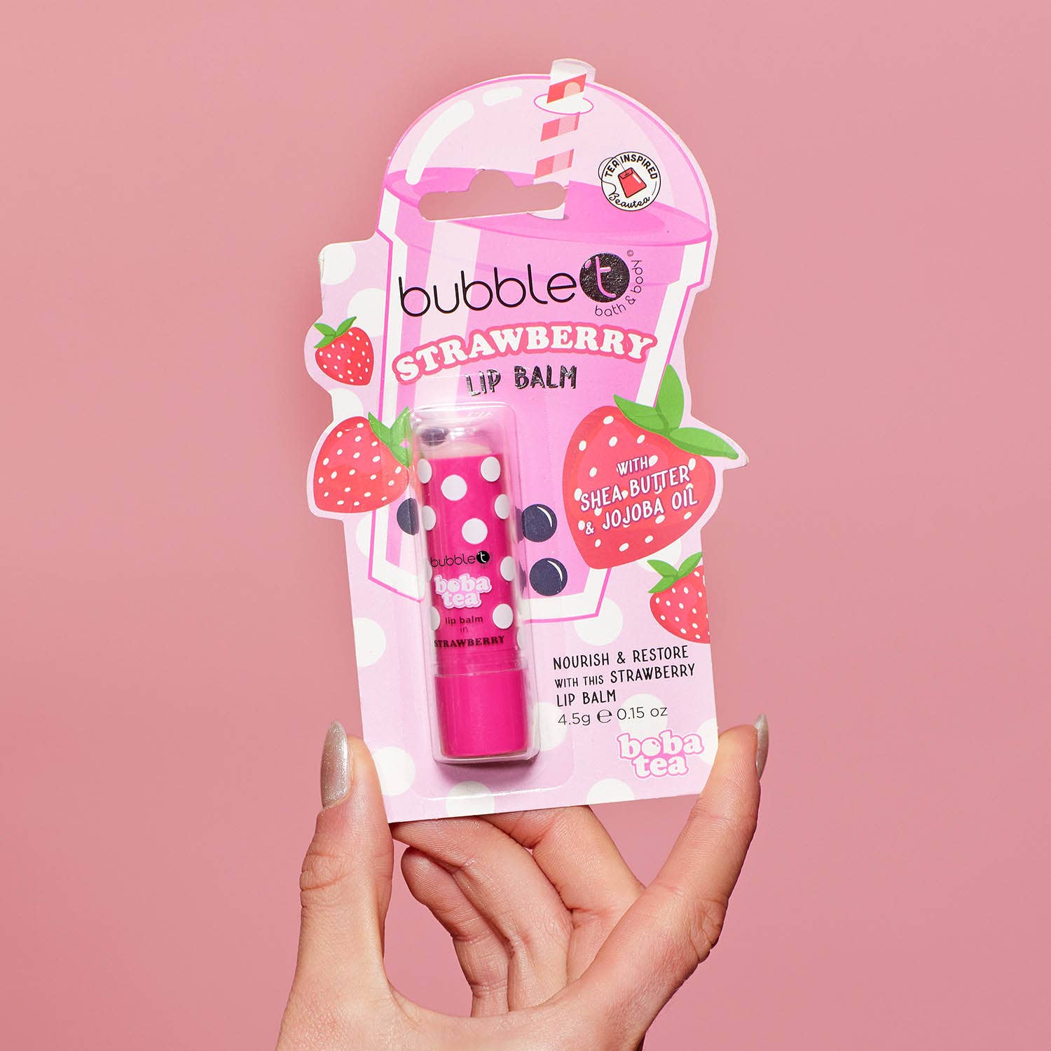 Pink strawberry lip balm with packaging.